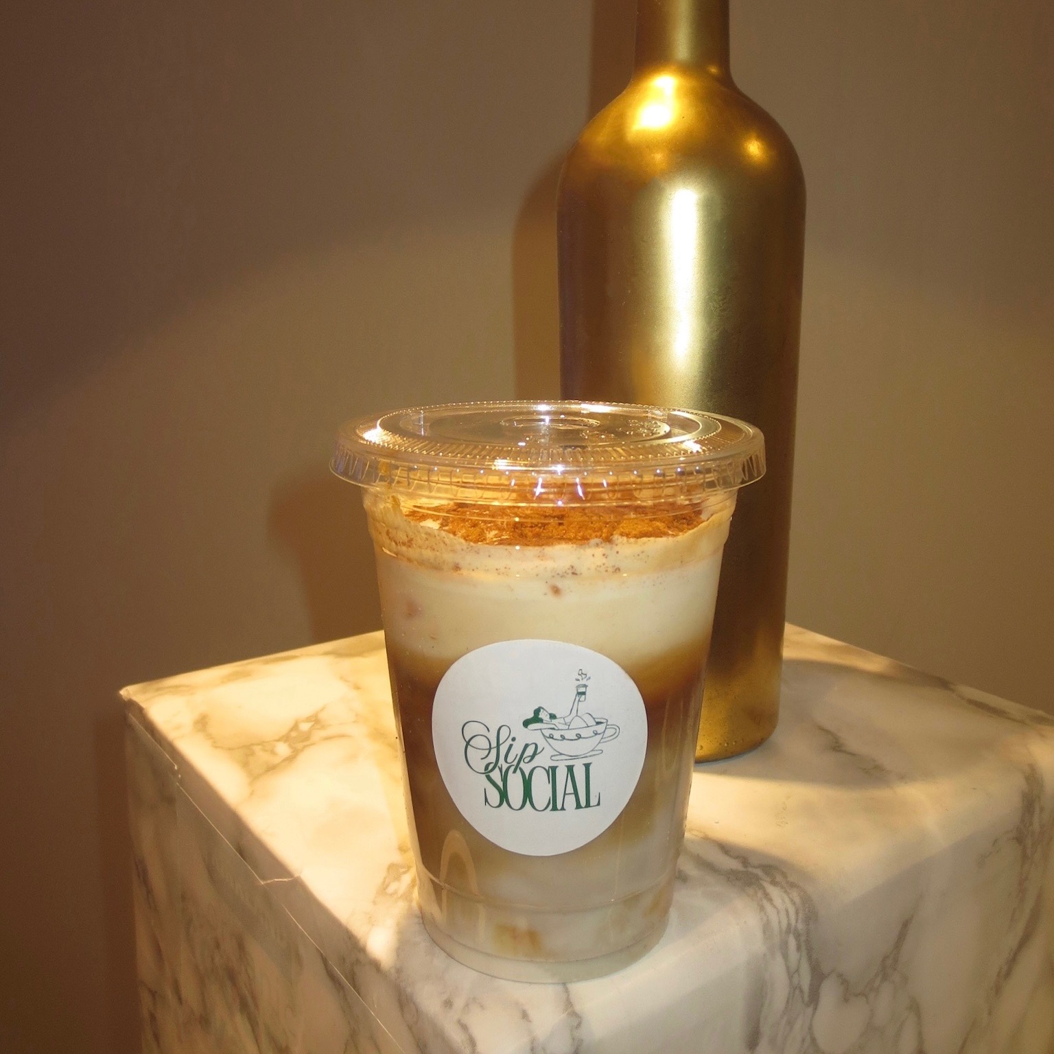 Signature tiramisu latte styled on marble with a gold accent